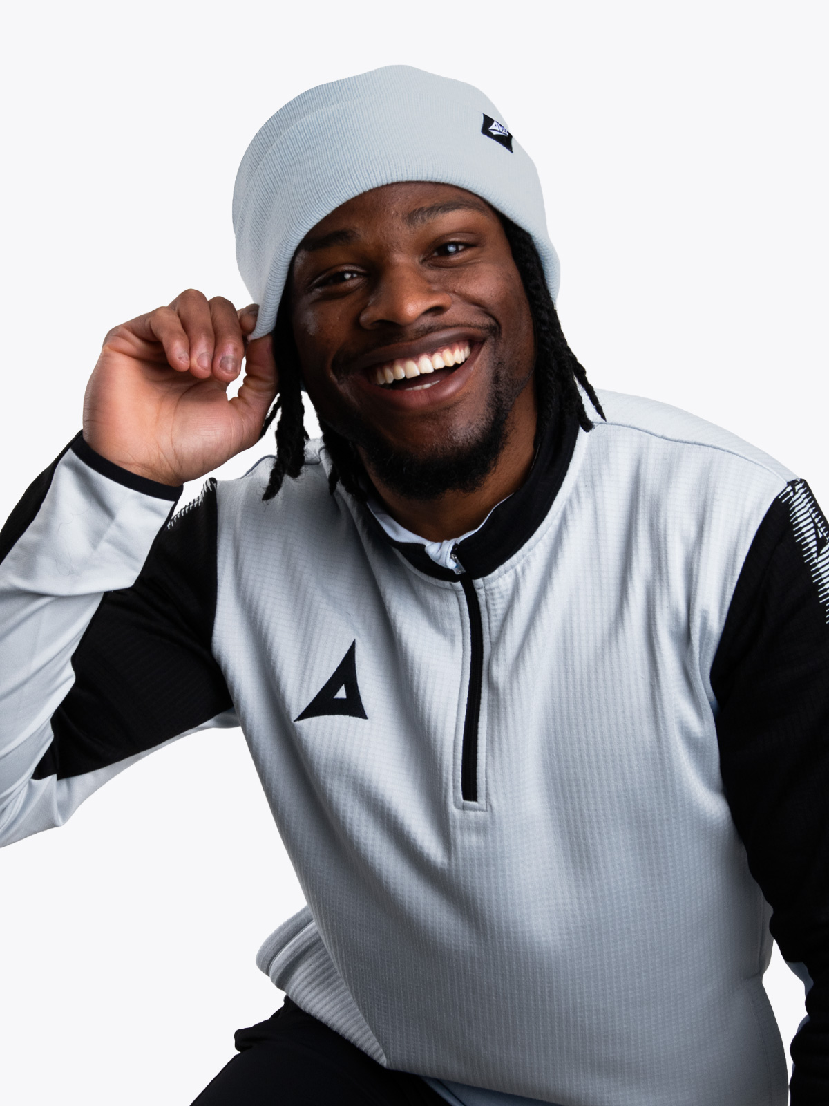 a model wearing a matching grey beanie and overlay smiling 