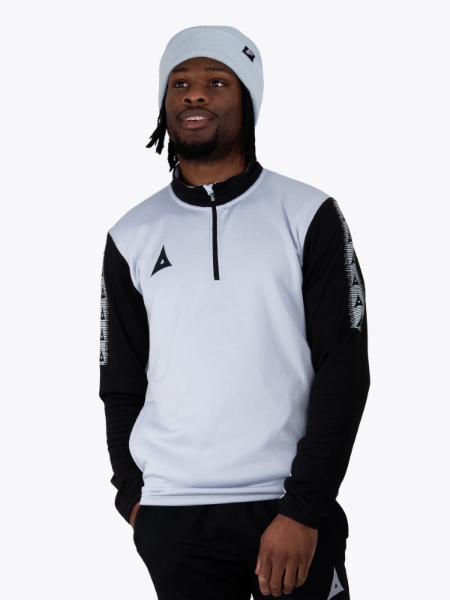 A model wearing a matching grey beanie and overlay with black accents and black track pant