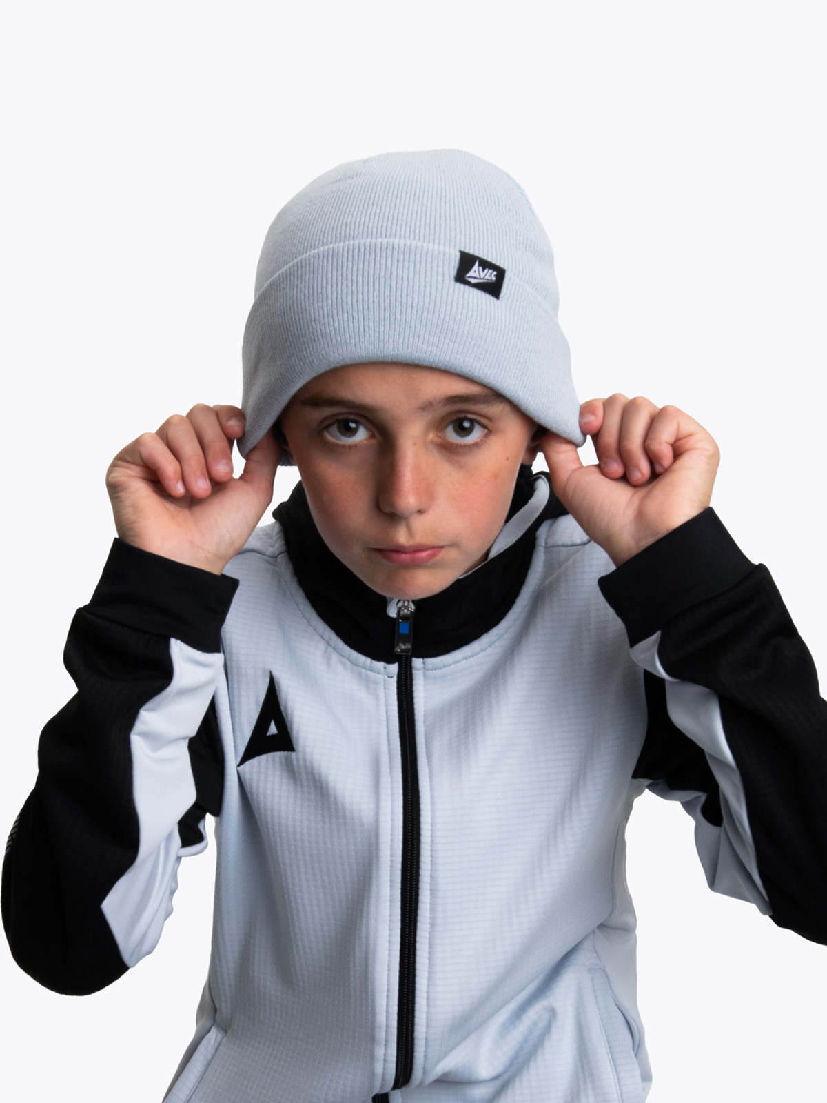 a junior model wearing a matching grey beanie and overlay with black accents