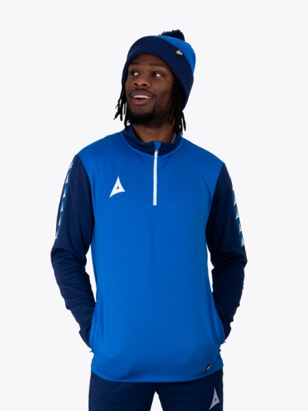 A man wearing a royal and navy blue bobble hat matching his overlay