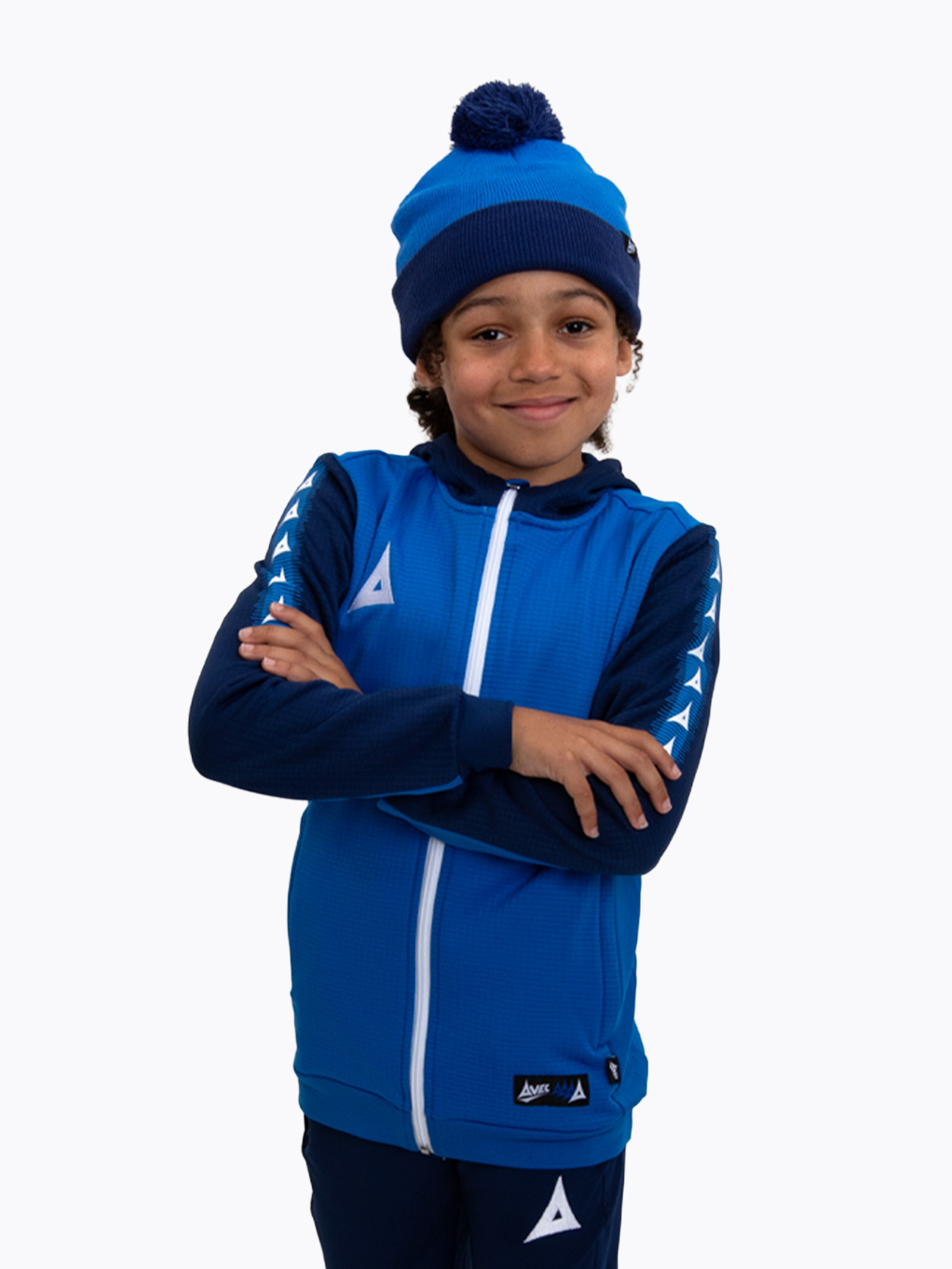 a young boy is wearing a royal and navy blue bobble hat matching his overlay