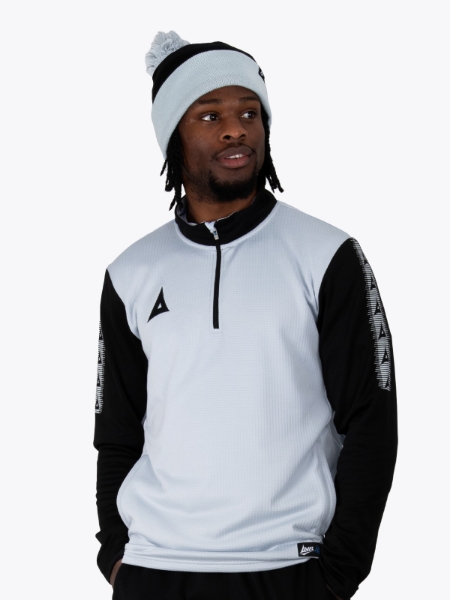 A man is wearing a grey bobble hat in black and grey matching his overlay
