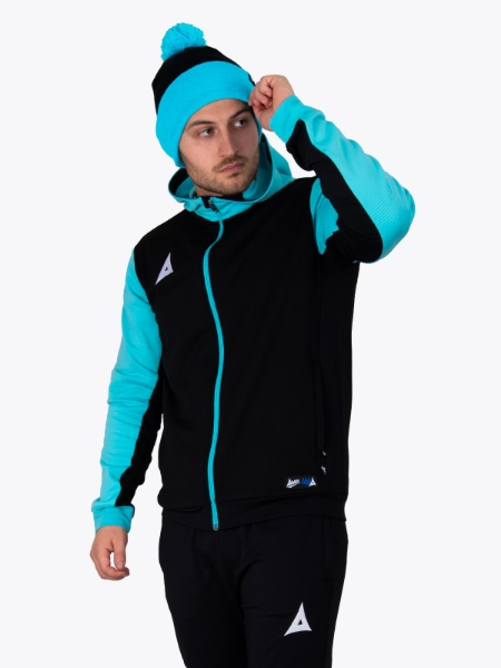 A male is standing up wearing a black and light blue bobble hat