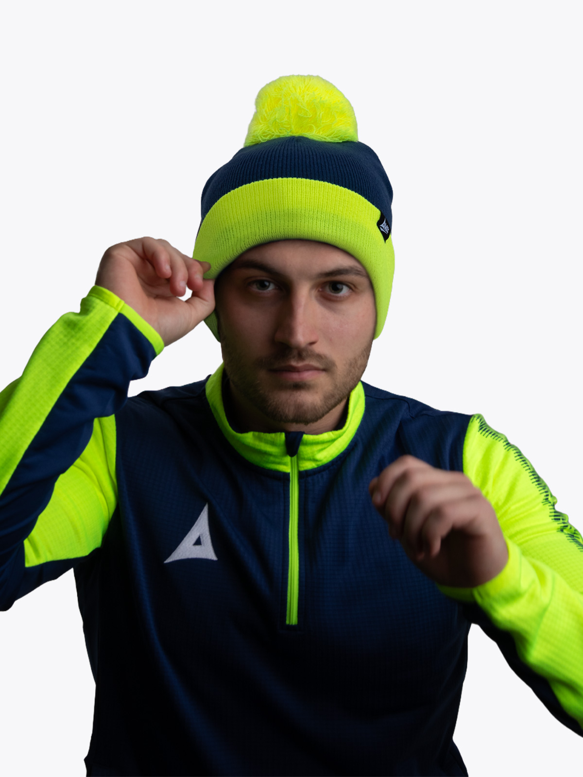 person wearing dark blue and neon yellow beanie and athletic jacket