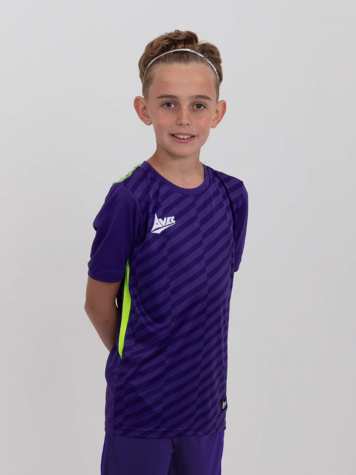a kids purple football shirt with neon yellow details is being worn by a young child.