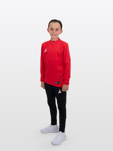 A boy is stood wearing the Avec Focus 2 Red Tech Overlay, Plain Red Jumper / Overlay with a Quarter Zip and the Avec Focus 2 Black Track Pant