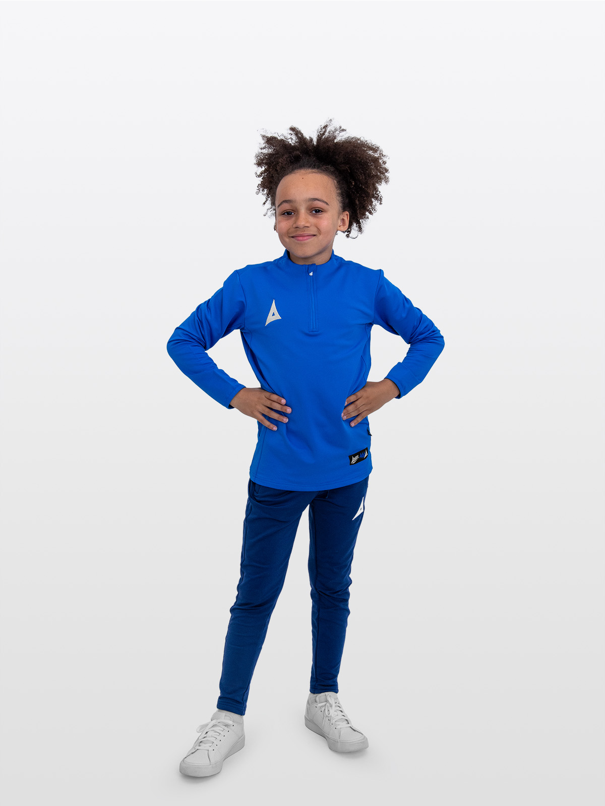 a boy dressed for training in the avec focus 2 royal tech overlay quarter-zip jumper, paired with avec focus 2 navy track pants.