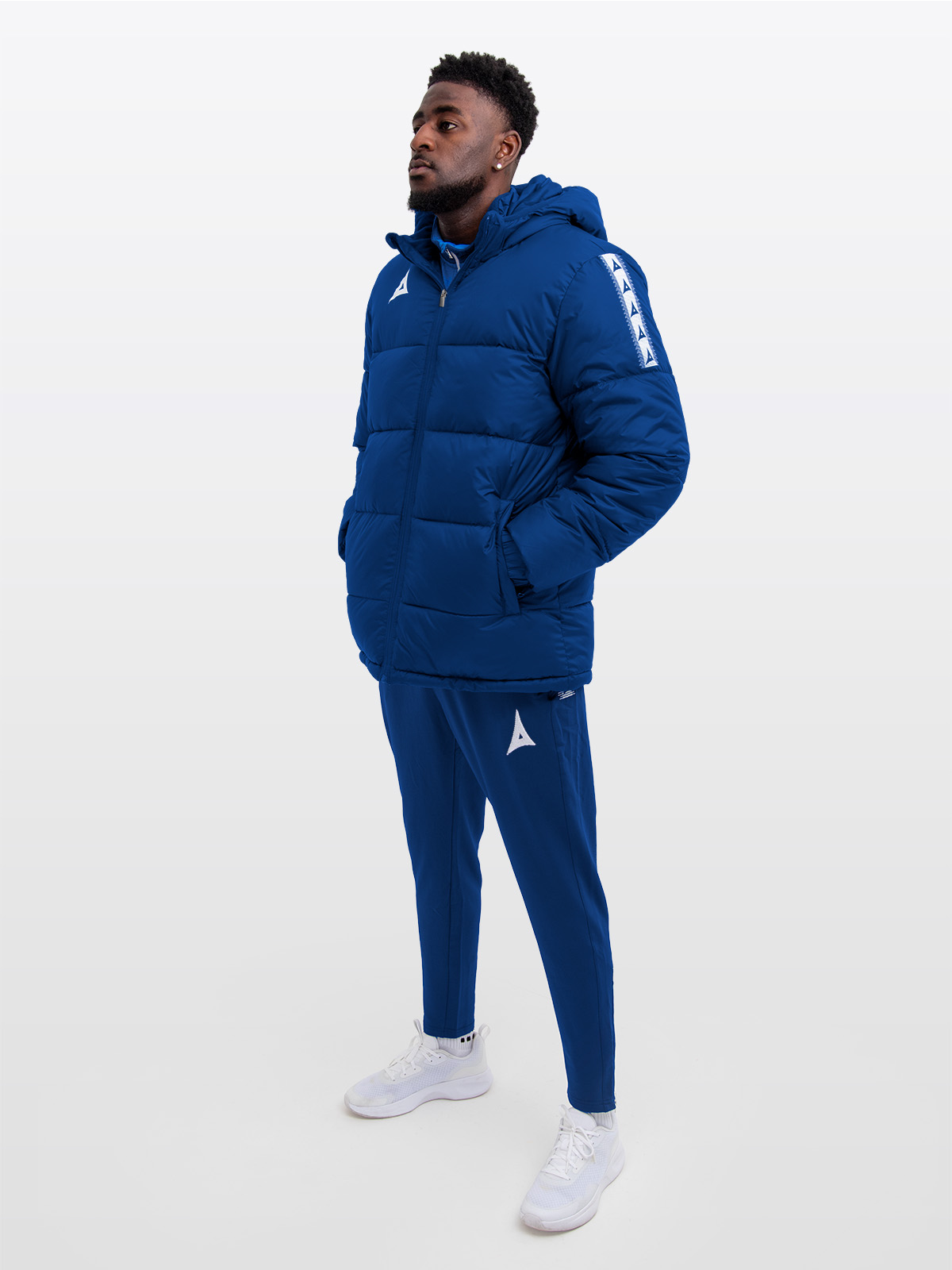 male model wearing the avec evolve pro padded jacket in navy featuring sewn-in panel detailing and medium padding for a refined, insulated fit. featuring matching avec navy evolve pro track pants 