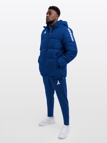 Male model wearing the Avec Evolve Pro Padded Jacket in Navy featuring sewn-in panel detailing and medium padding for a refined, insulated fit. Featuring matching Avec Navy Evolve Pro Track Pants 
