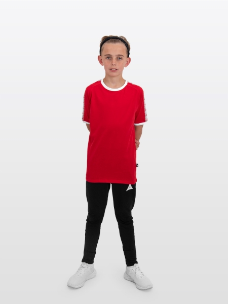 A boy is stood wearing wearing the Avec Evolve Red T-Shirt and the Avec Focus 2 Black Track Pant