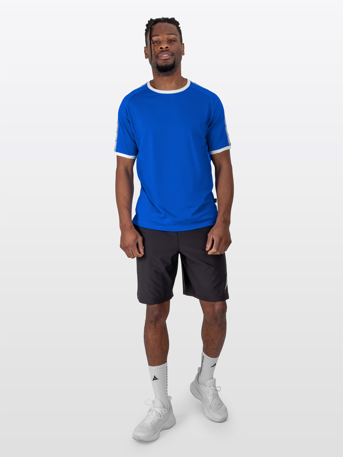 a male model is stood wearing the avec evolve royal blue t-shirt, and black avec focus 2 tech shorts and avec grip socks in white
