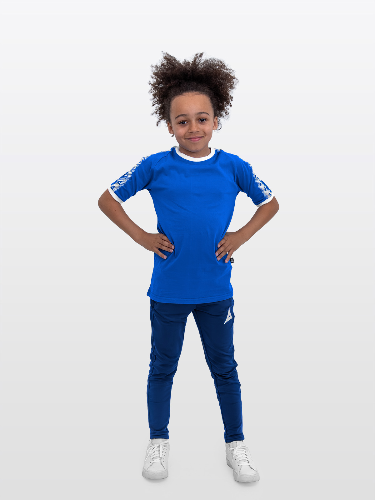 a boy is stood wearing wearing the avec evolve royal blue t-shirt and the avec focus 2 navy track pant