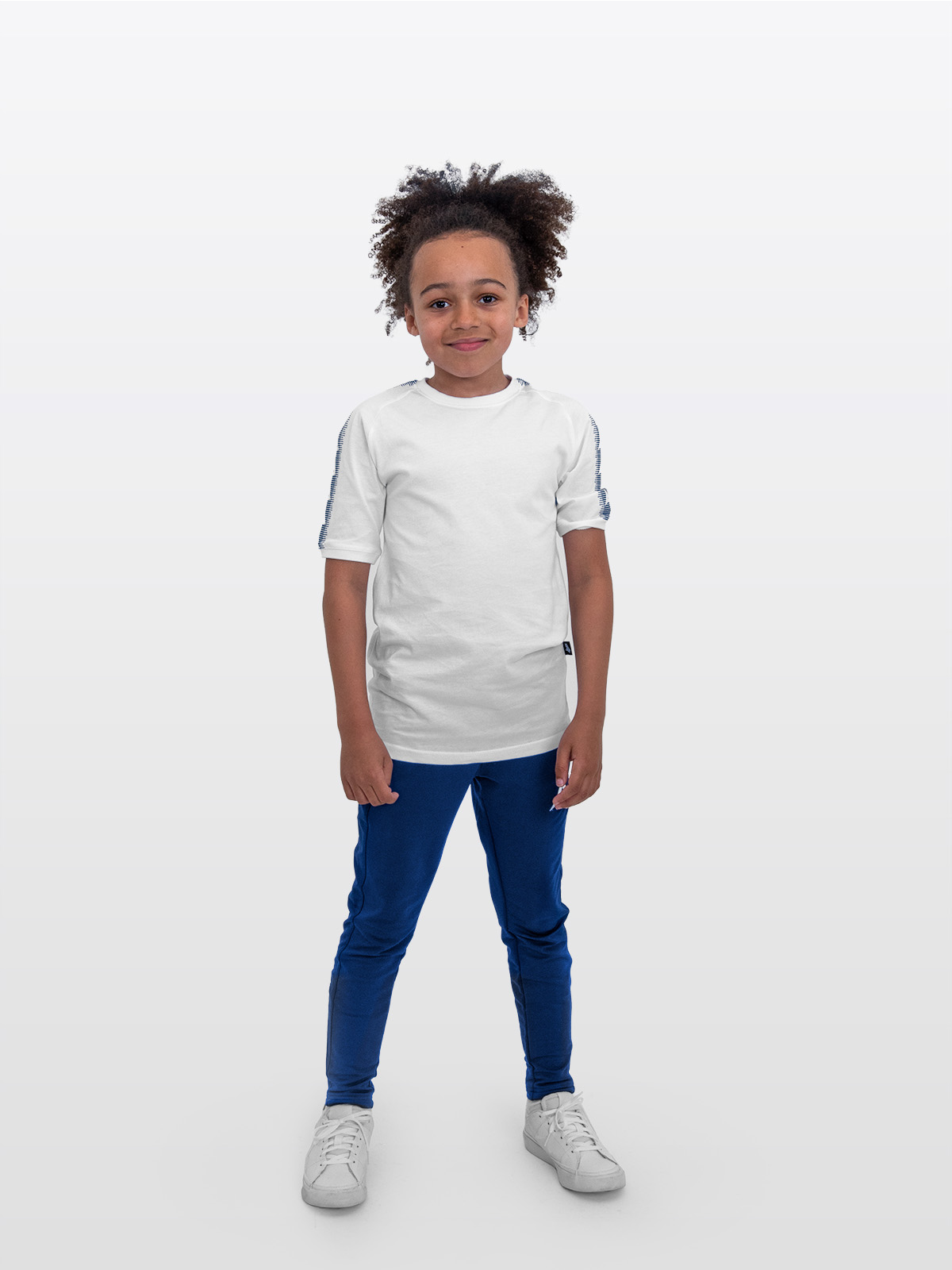 a boy is stood wearing wearing the avec evolve white t-shirt and the avec focus 2 navy blue track pant