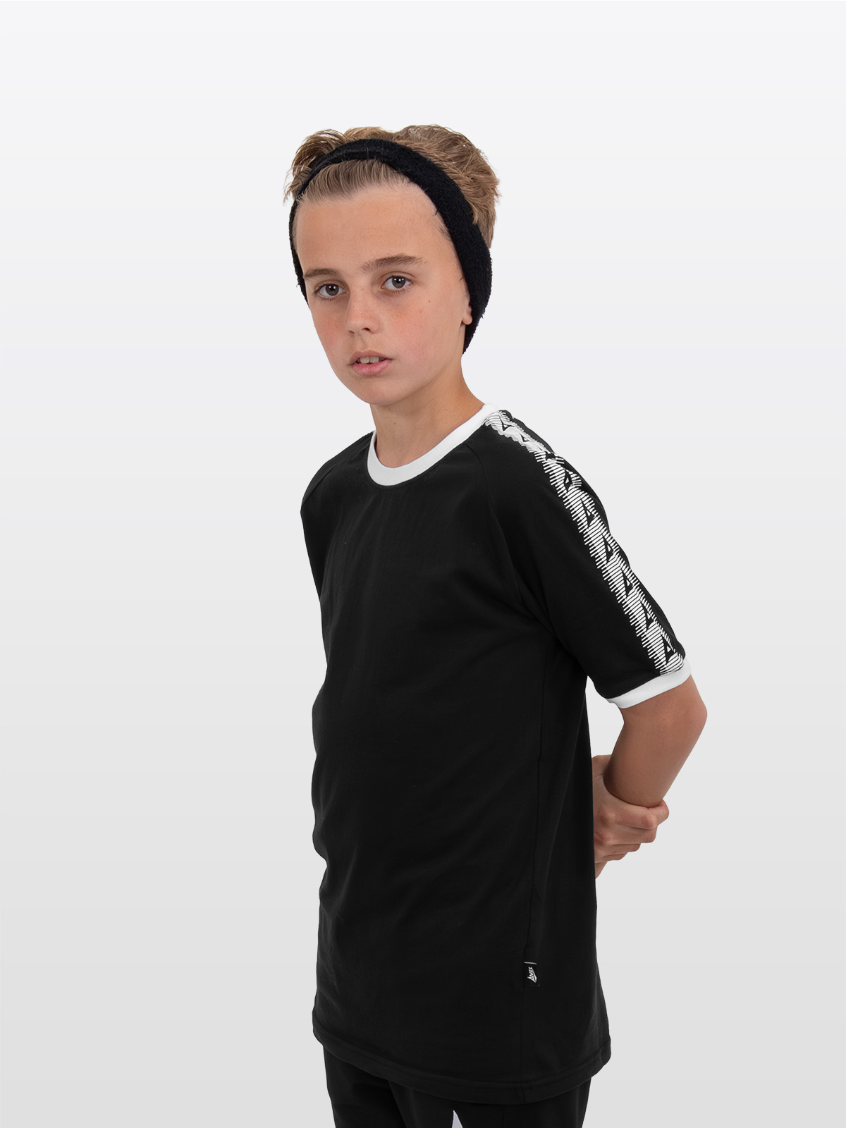 a boy is stood wearing wearing the avec evolve black t-shirt, plain cotton top with sleeve detail