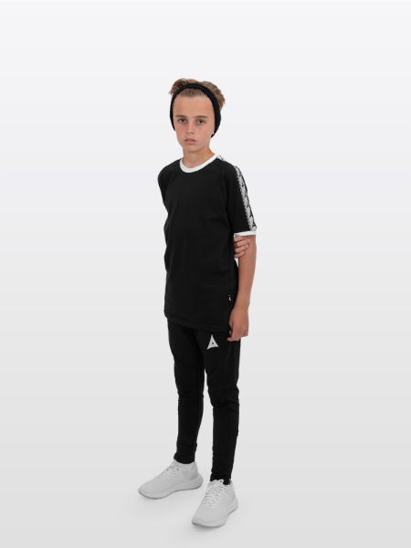 A boy is stood wearing wearing the Avec Evolve Black T-Shirt and the Avec Focus 2 Black Track Pant