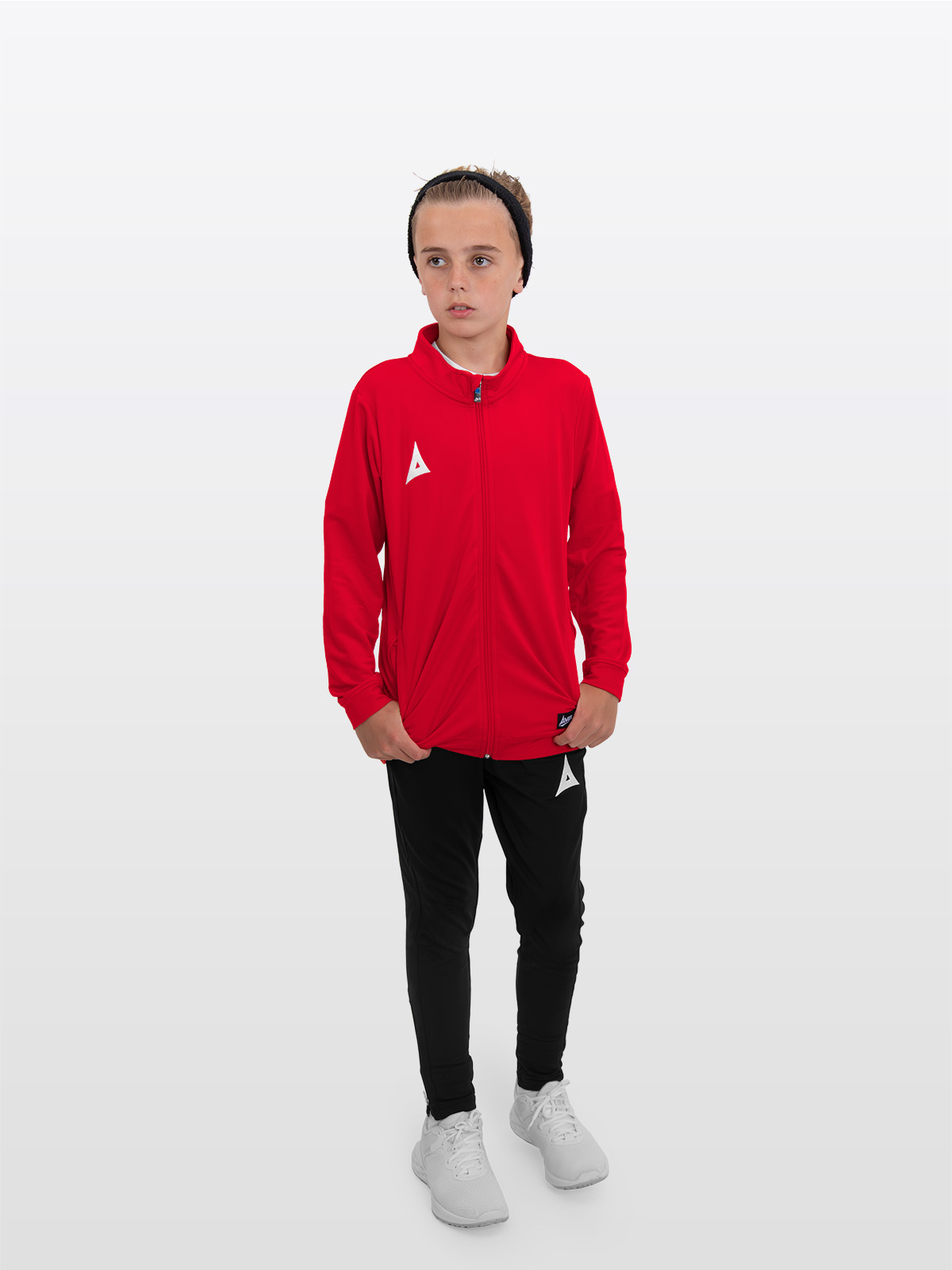 a boy is stood wearing the avec focus 2 red track jacket, plain red full zip and the avec focus 2 black track pant