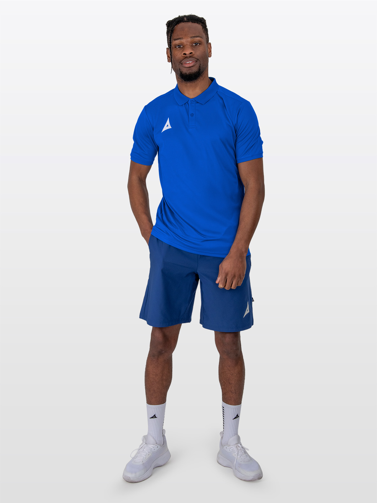 a male model is stood wearing the avec focus 2 royal tech polo, plain royal blue top and the avec focus 2 navy track pant