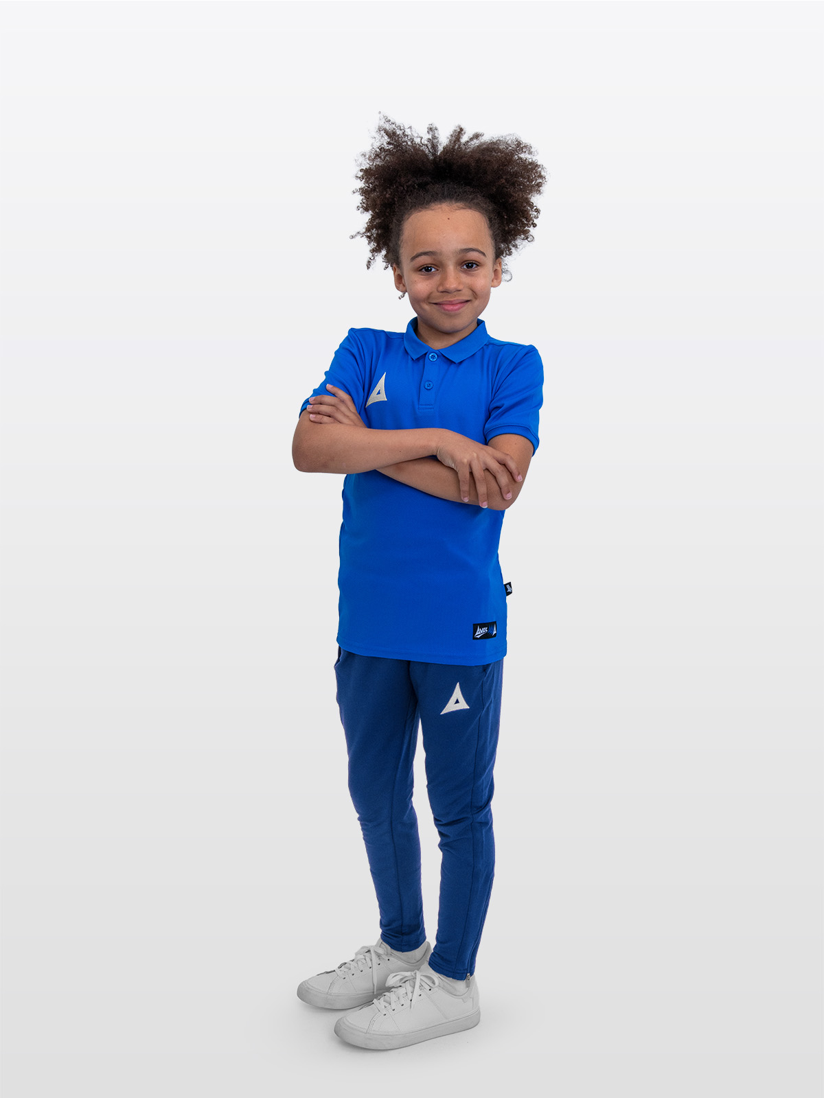 a boy is stood wearing the avec focus 2 royal tech polo and the avec focus 2 navy track pant