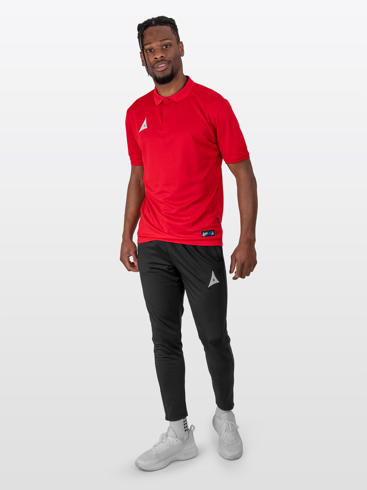 a male model is stood wearing the avec focus 2 red tech polo and the avec focus 2 black track pant joggers