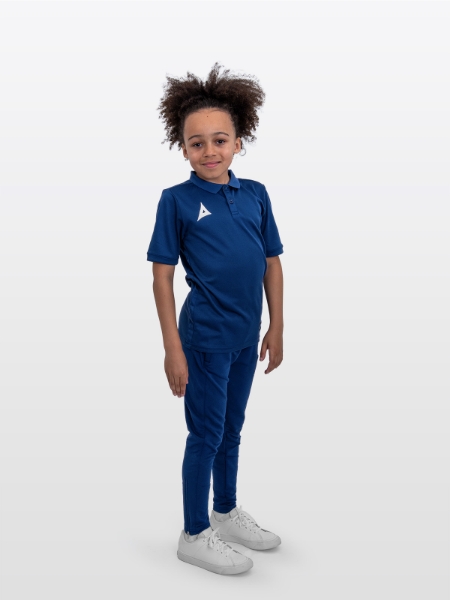 A boy is stood wearing the Avec Focus 2 Navy Tech Polo and the Avec Focus 2 Navy Track Pant for a smart combination