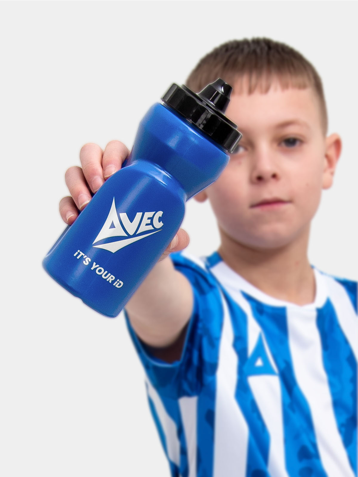 a kid is wearing a royal blue football shirt with white stripes and is holding a matching royal blue water bottle with a self sealing nozzle