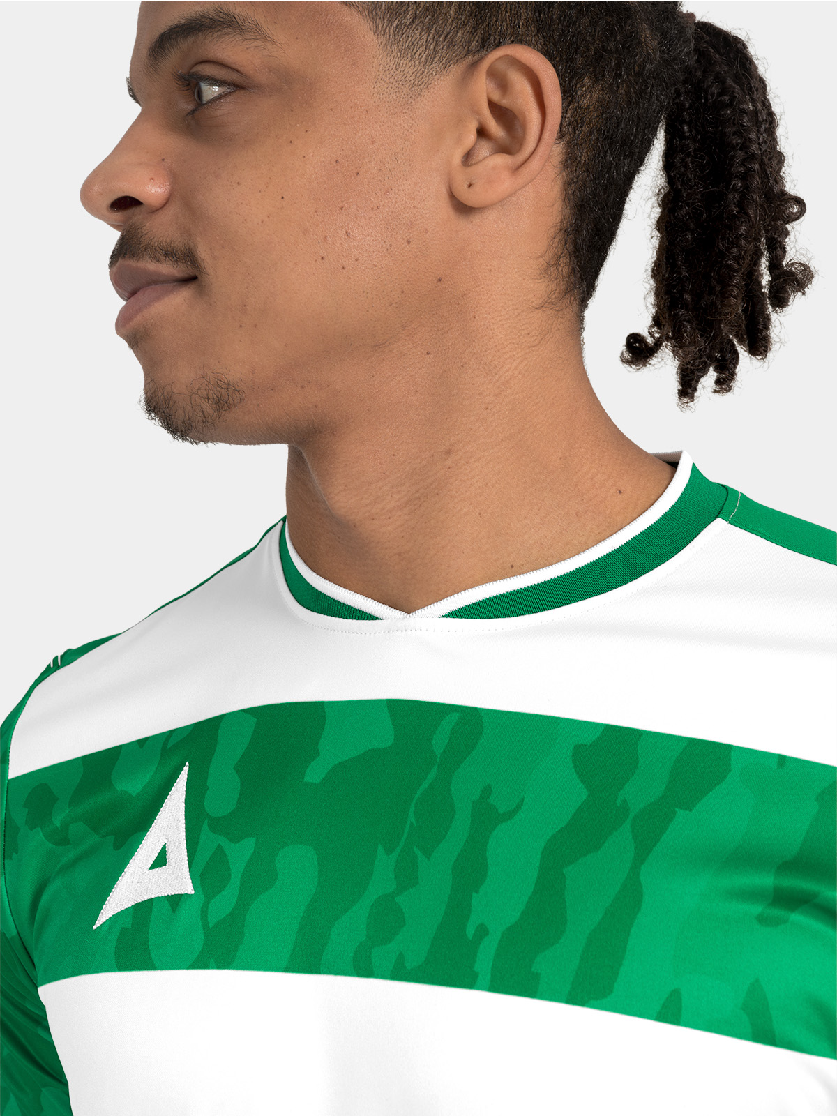 detail of the v-neck construction and internal branding on the green and white pro intent matchday shirt.