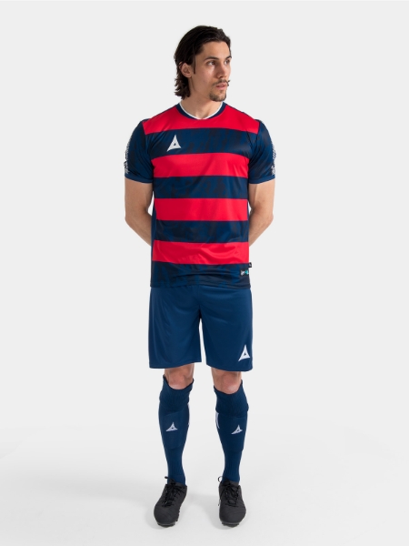 Complete Navy and Red matchday kit on-model, demonstrating the professional on-pitch appearance.