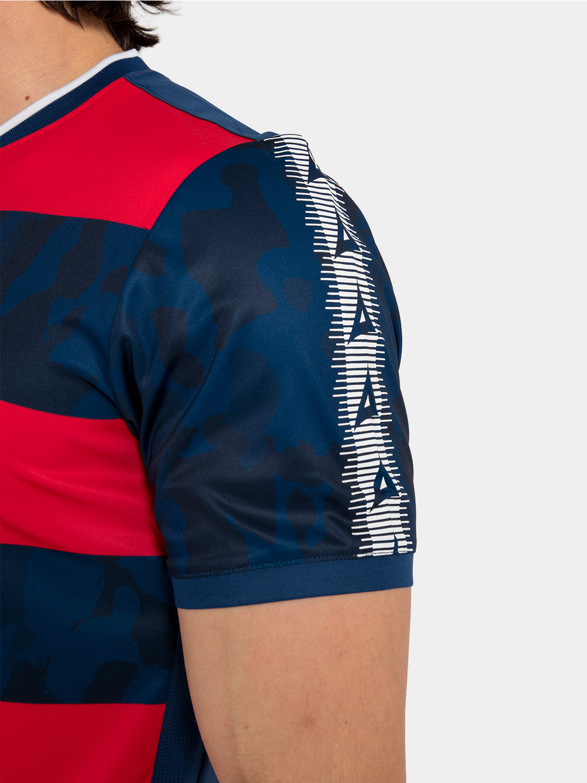 detailed view of the navy and red jersey shoulder, featuring the iconic repeating avec 'a' branding.