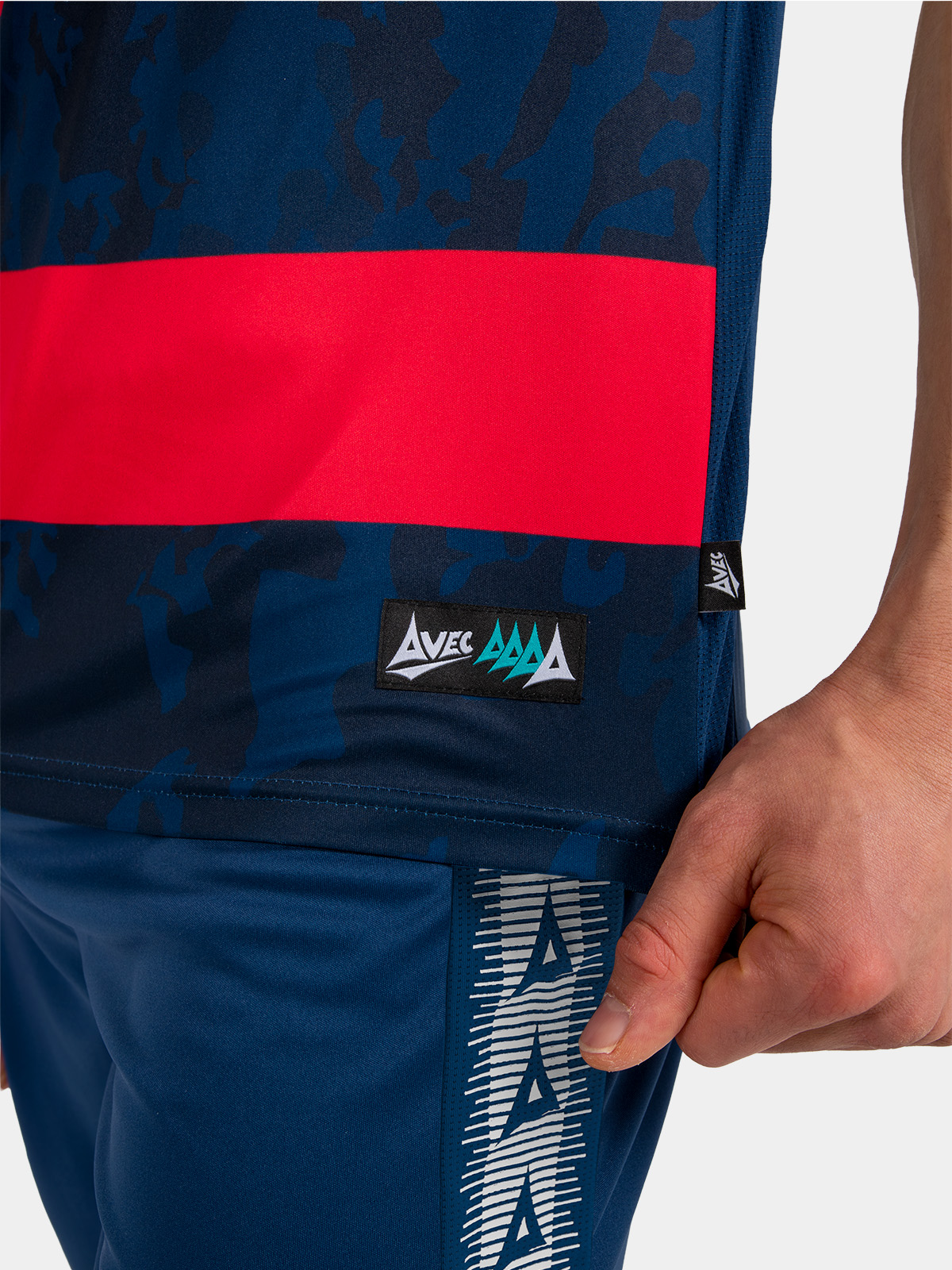 detail of the navy and red jersey side-seam, showcasing the breathable mesh ventilation and woven hem label.