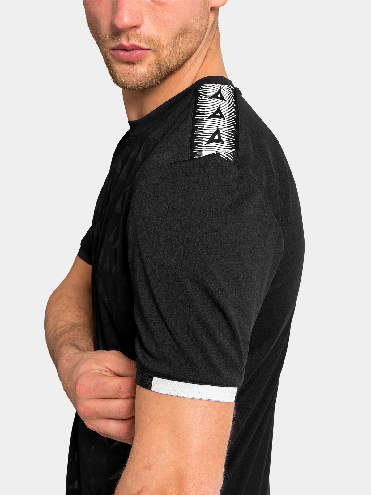 close-up of the black jersey sleeve featuring the iconic heritage 'a' logo taping along the shoulder.