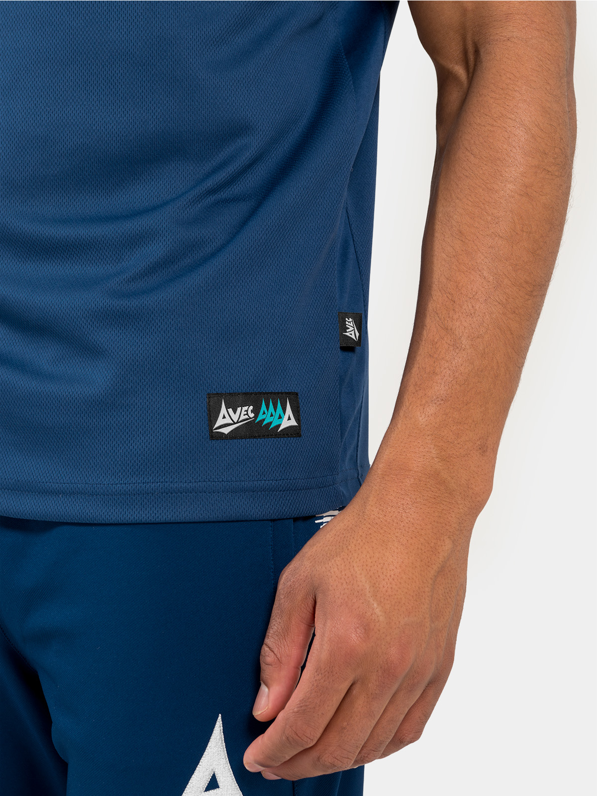 side-hem detail of the navy polo, featuring the mesh ventilation and official authenticity tag.