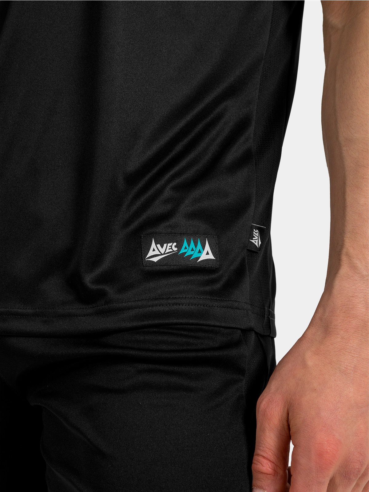 side hem view of the black jersey, showing the official authenticity label and moisture-wicking mesh.