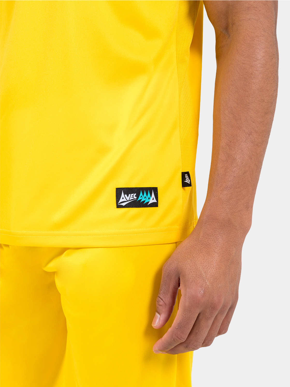 side seam detail of the yellow jersey, showing the moisture-managing mesh inserts and woven authentic id label.