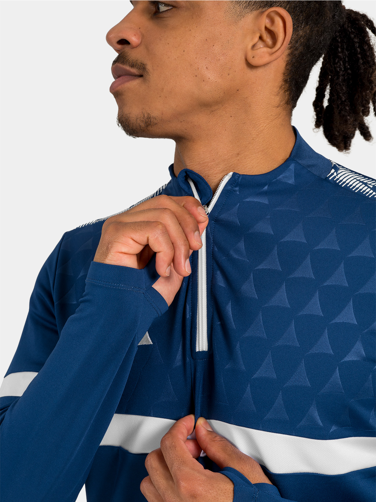 macro detail of the navy 1/4 zip fully closed, showing the debossed heritage 'a' panel and reinforced stitching.