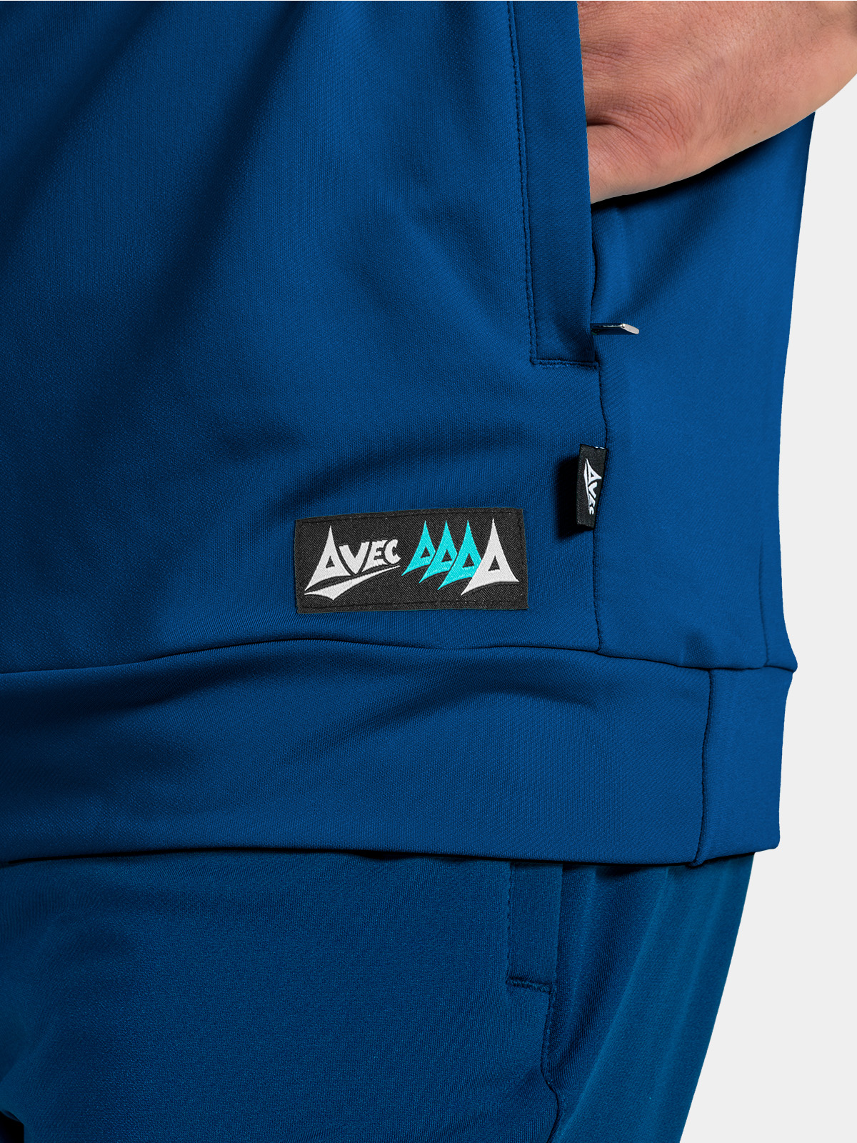 side hem detail of the navy hoody, highlighting the zipped pocket and official product authenticity tag.