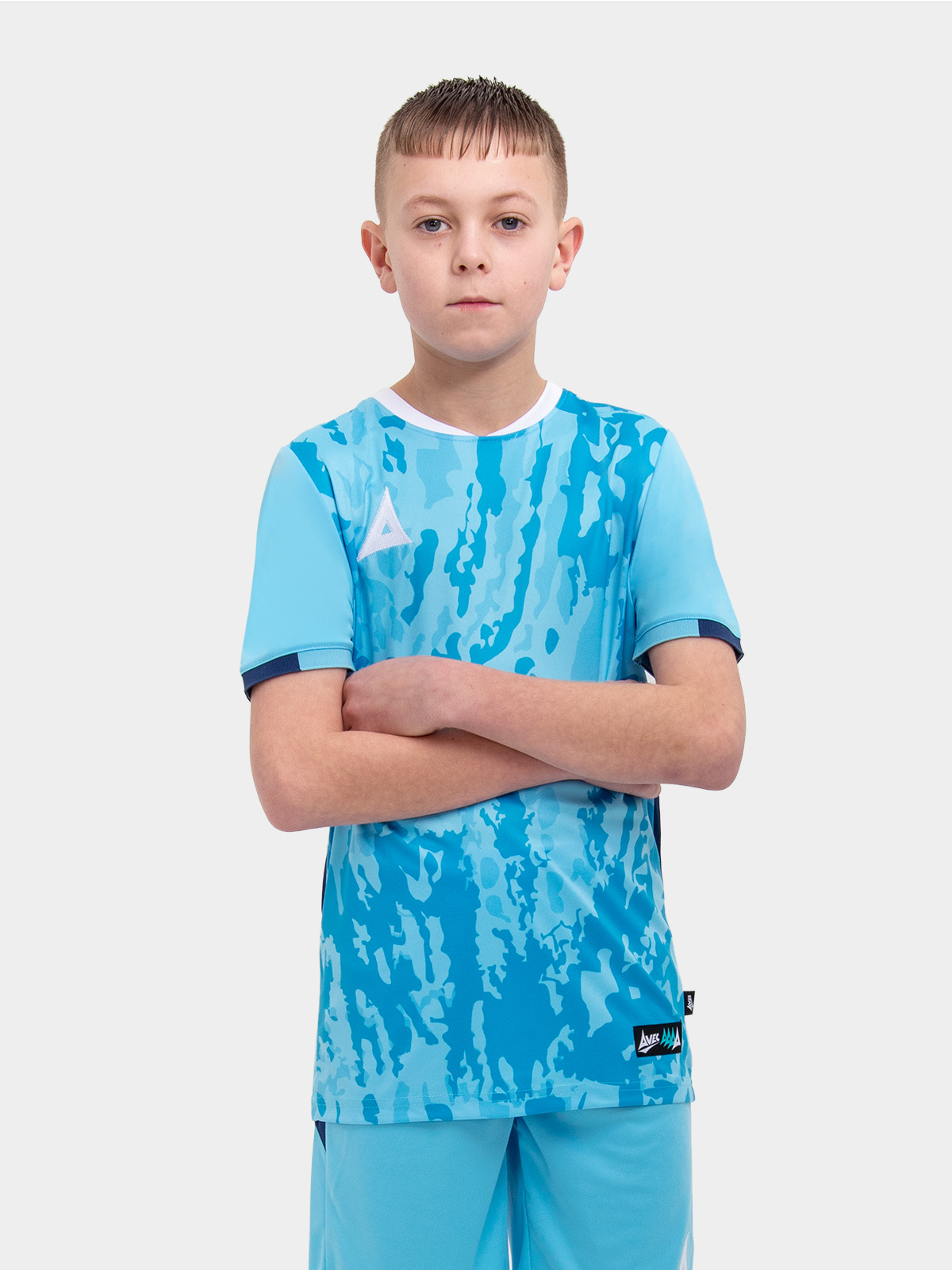 a young child is wearing a sky and navy football shirt. the football shirt has a camo pattern