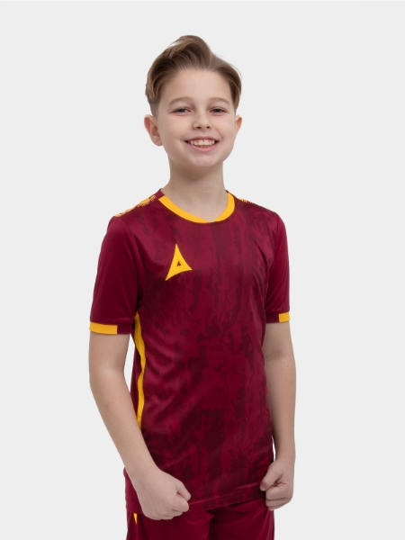A young child is wearing a claret / maroon and amber Football Shirt. The football shirt has a camo pattern