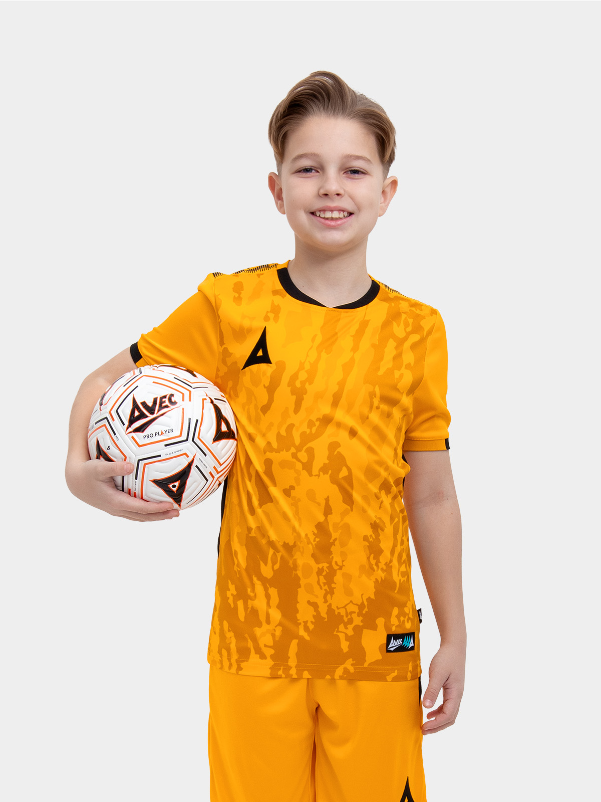 a young child is wearing an amber and black football shirt. the football shirt has a camo pattern