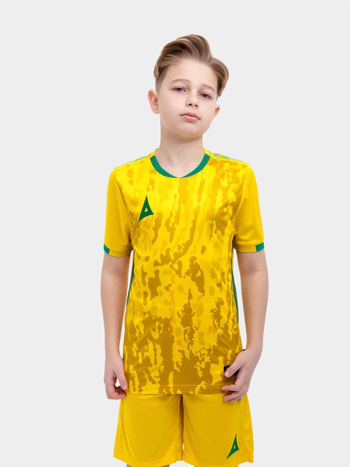 	a young child is wearing a yellow football shirt. the football shirt has a camo pattern and green accent details