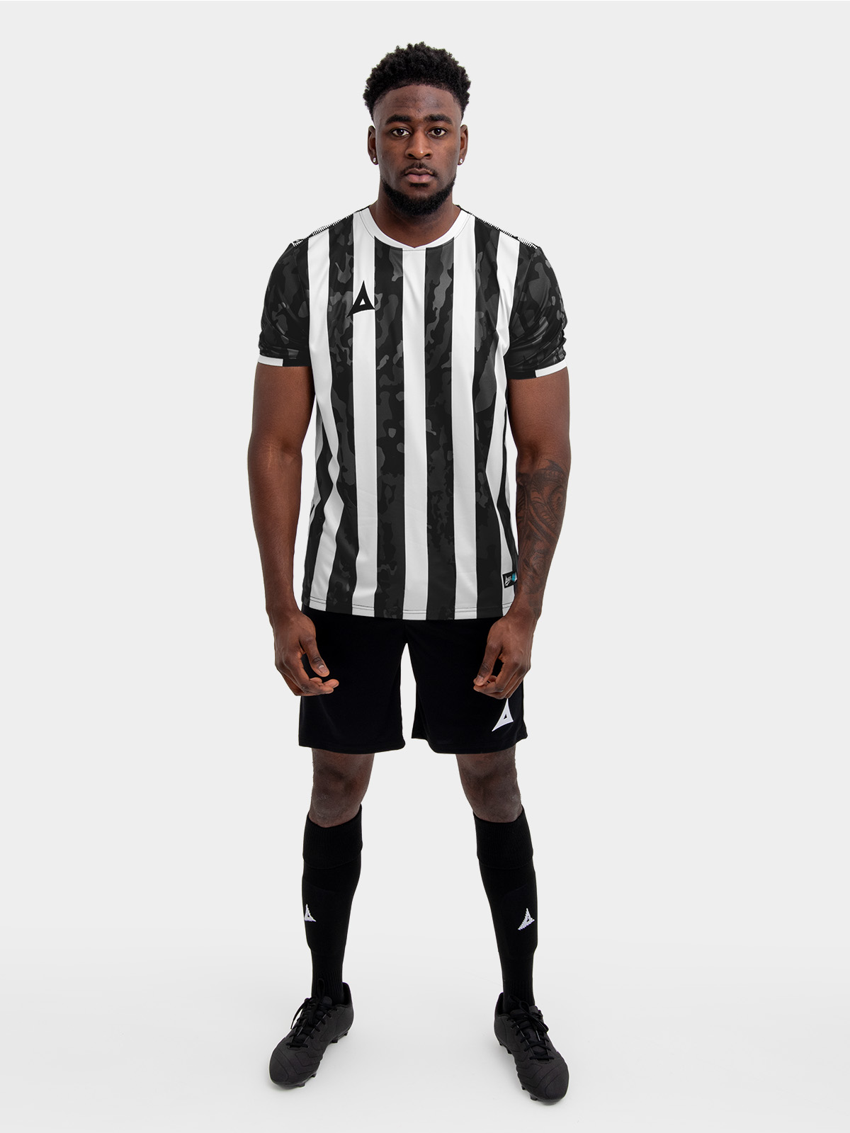 a man in a black and white stripe shirt, black shorts and socks.