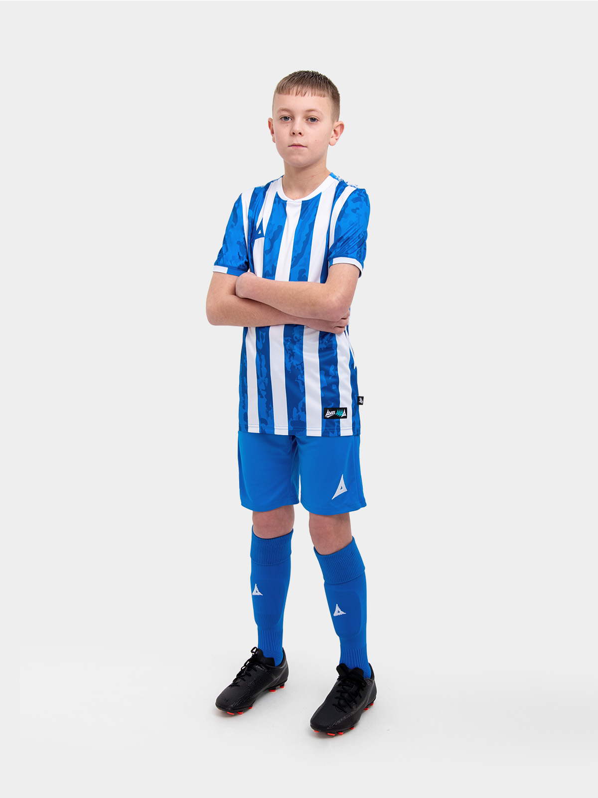a kid is wearing a blue and white football shirt, and paired it with blue shorts and blue socks