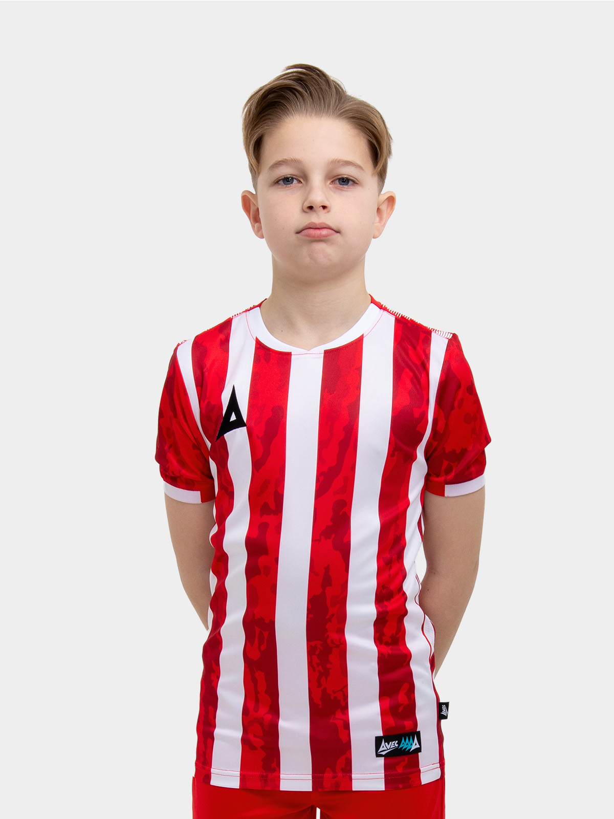 	a young child is wearing a red and white striped football shirt. the football shirt has a camo pattern
