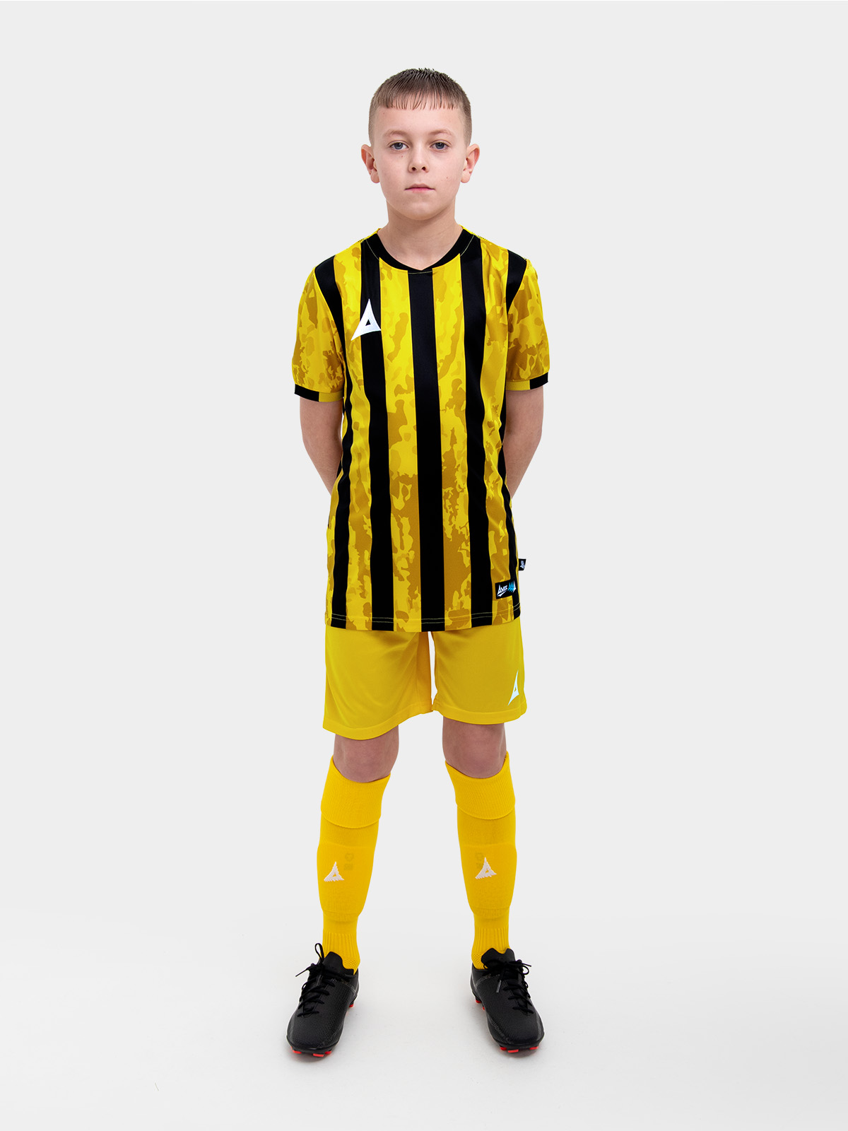 a kids football kit in yellow and black with stripes and matching yellow shorts and socks