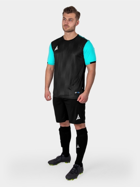 A man is wearing a Black Football Shirt with pale blue sleeves, black shorts and light blue socks.