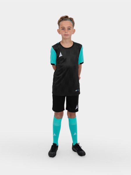 A junior model is wearing a childrens black football t-shirt, black shorts and turquoise football socks