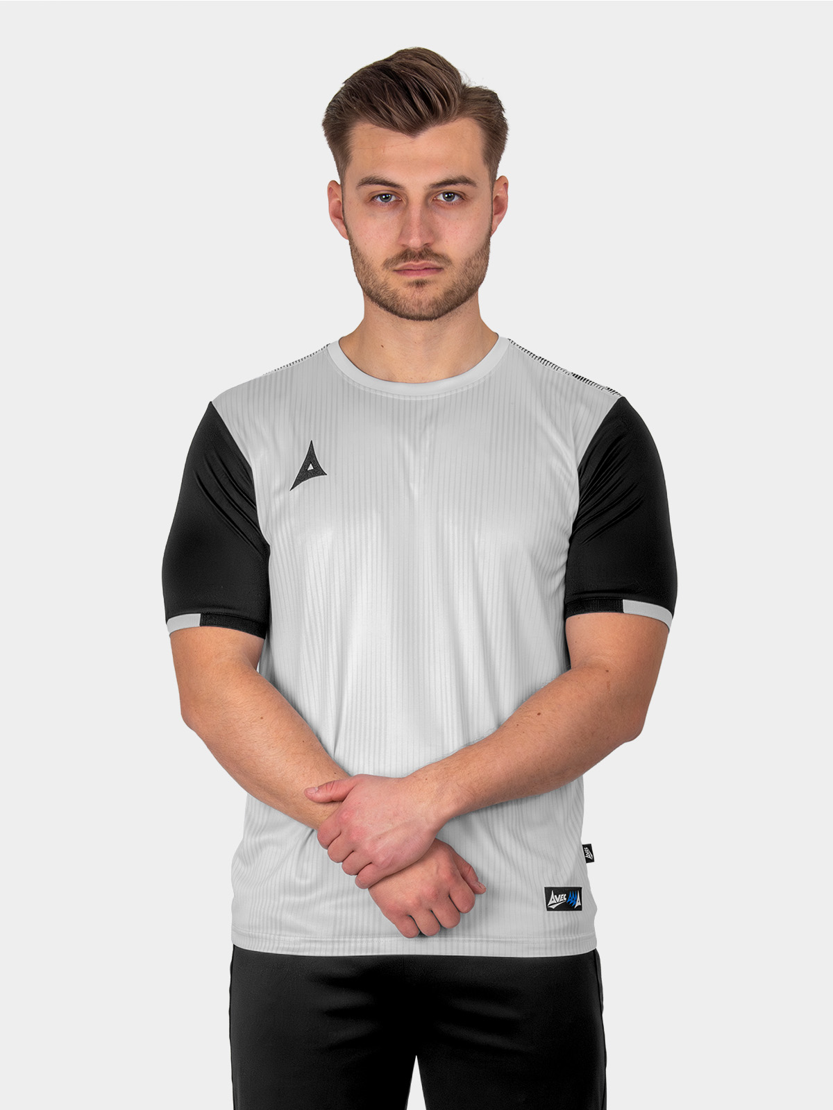 a man is wearing a grey football shirt with a graphic print design and black sleeves