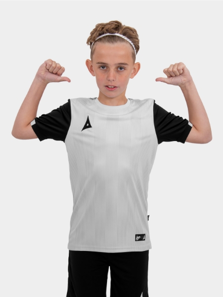 A child is wearing a grey football shirt in a junior size.