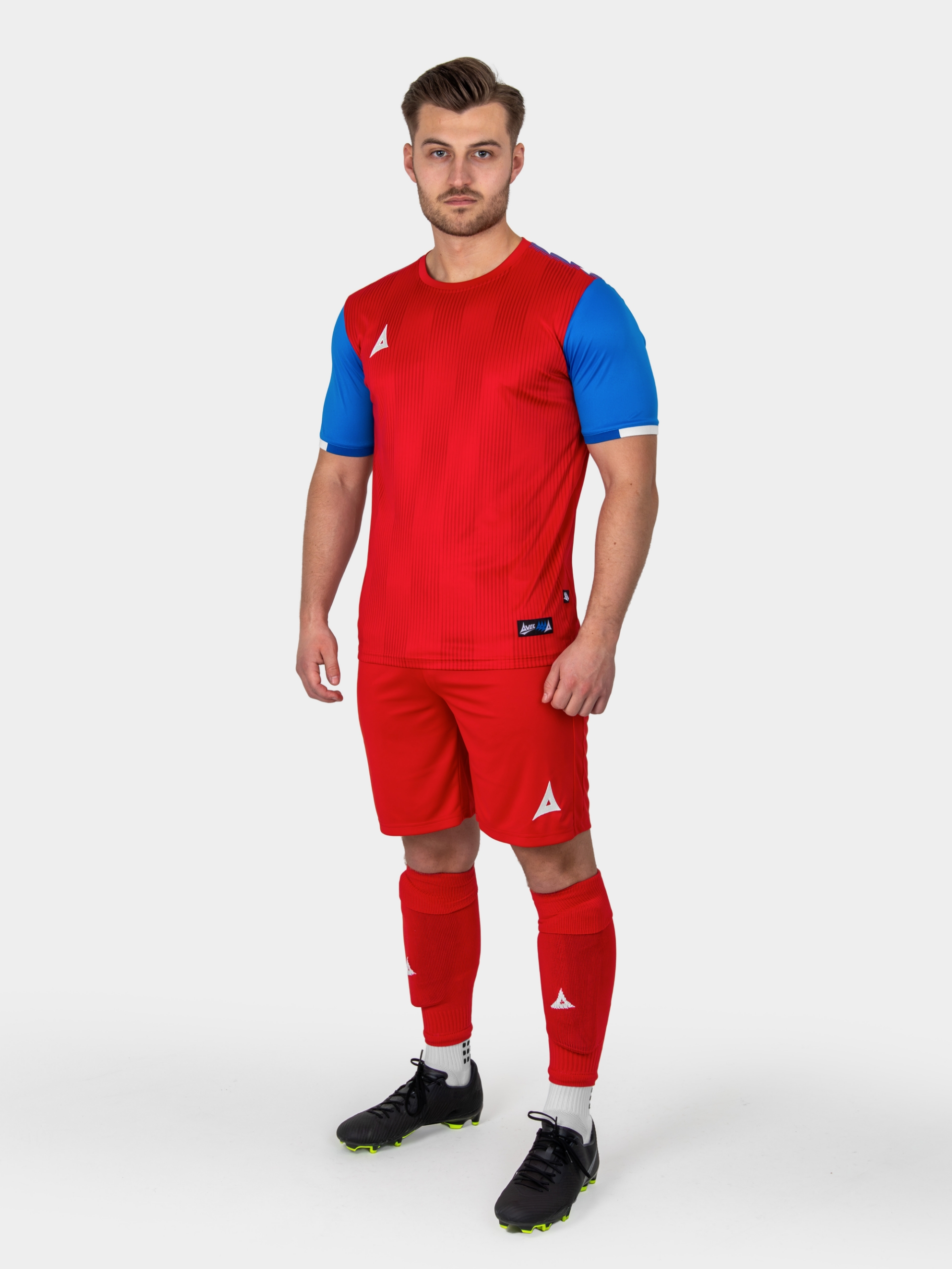a model is wearing a red and royal blue football kit