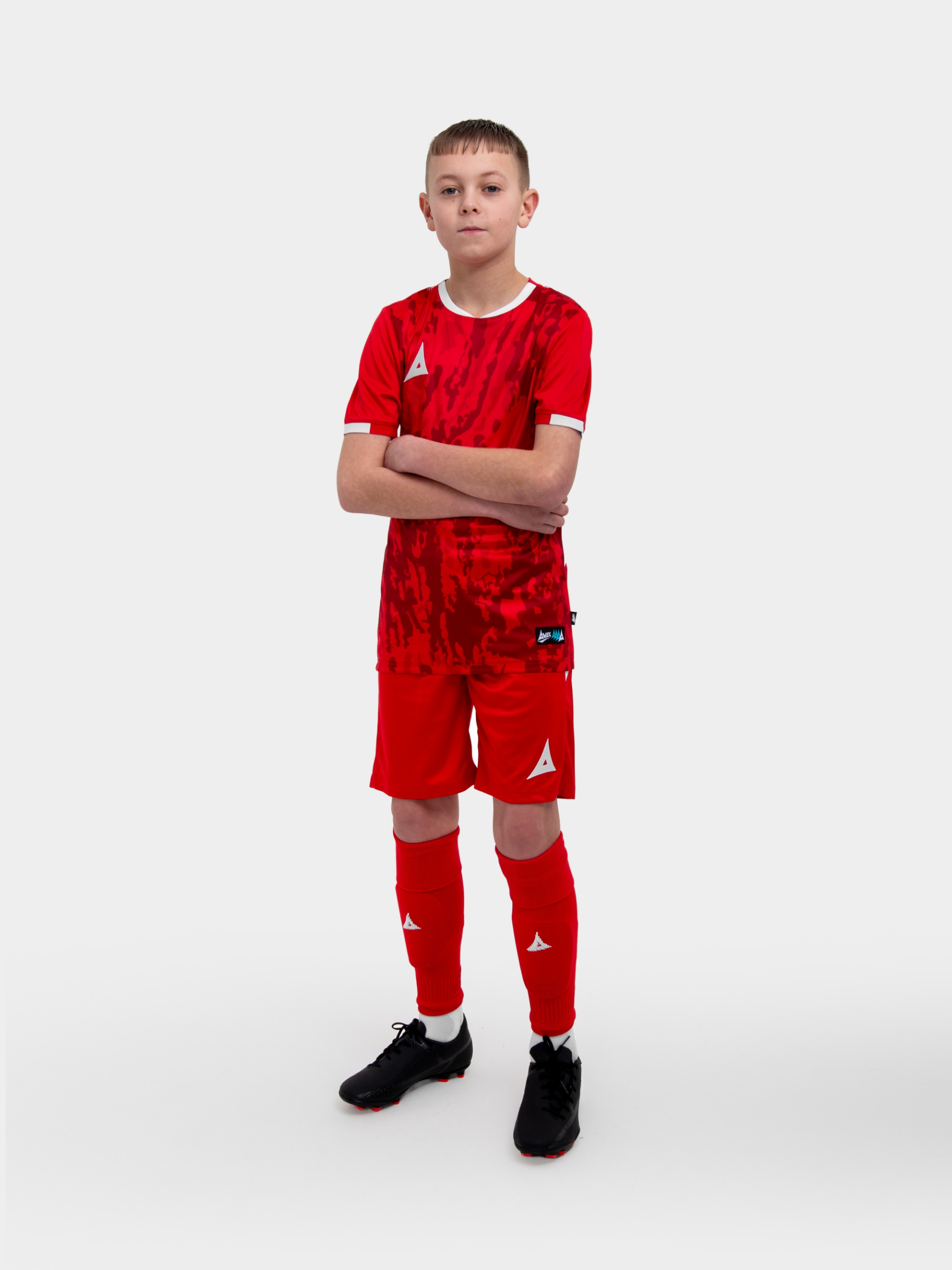 a child is wearing a red and football kit