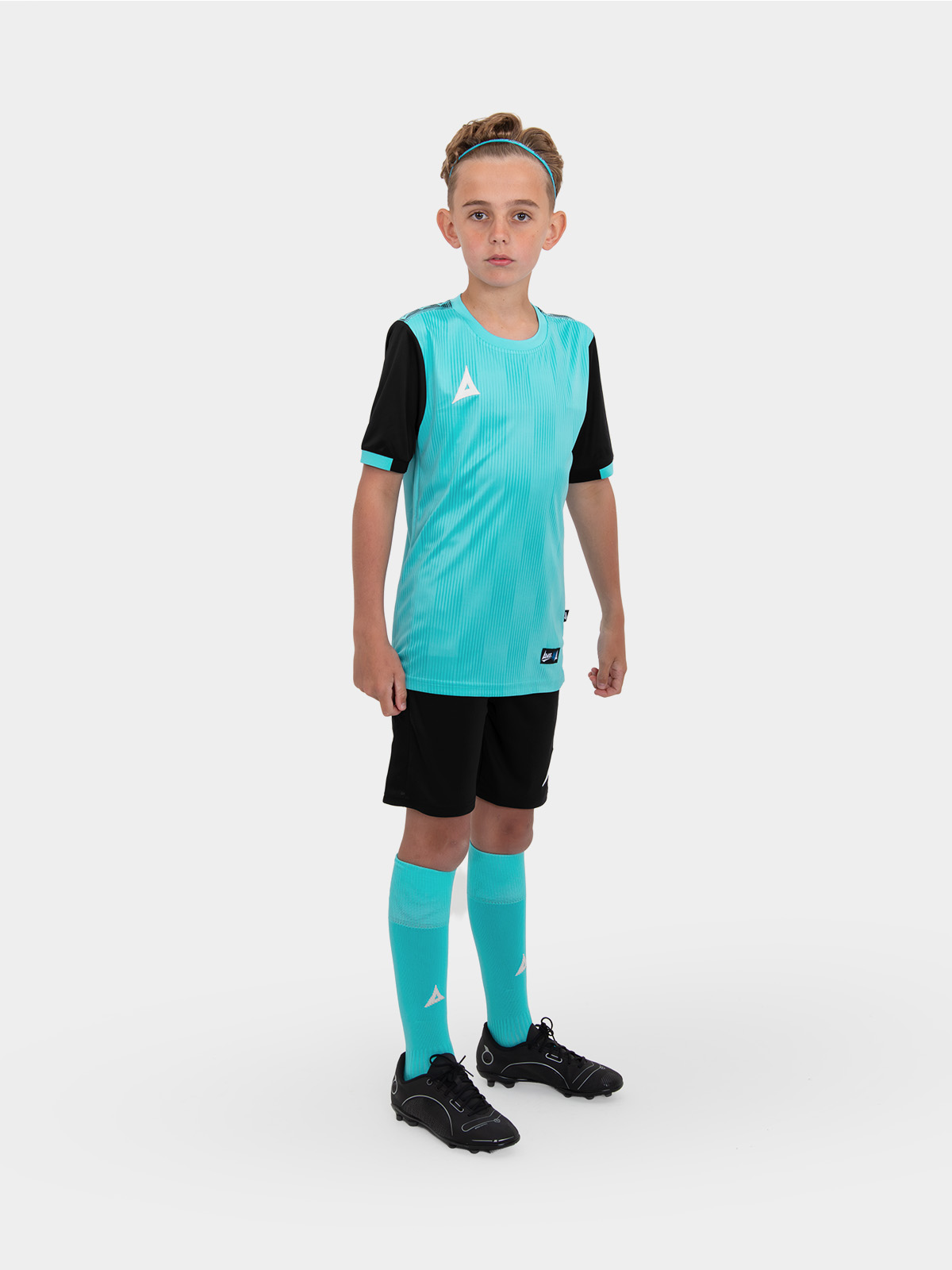 	a child wearing a junior football kit which is light blue and black
